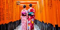Geisha women standing near Torii Gate in Kyoto, Japan