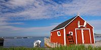 A red house on the dock with white moose antlers above the door at L'Anse aux Meadows