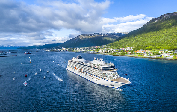 Aerial view of a Viking ocean ship sailing past a European town