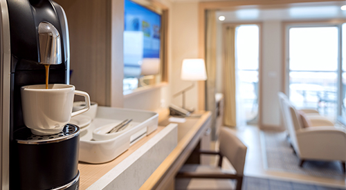 A closeup of an in-room coffee maker inside of a Viking Ocean Explorer Suite.