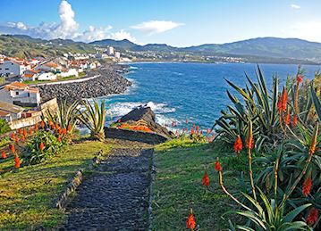 A pathway leading to the beach and lined with flowers at Azores Coastal village
